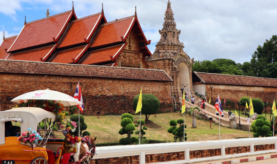 cover Riding a horse carriage to pay respects at Phra That Lampang Luang, Lampang Province.