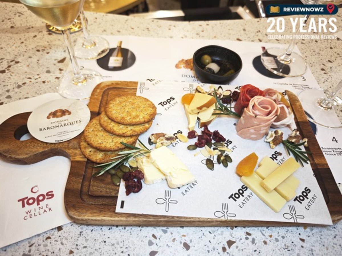 ชุดถาดไม้ Cold Cuts และ Cheese Platter ประกอบด้วยชีสหลากชนิด พรีเมียมแฮมสไลด์รูปดอกไม้ แครกเกอร์ และผลไม้อบแห้ง เสิร์ฟในงานไวน์เทสติ้ง Tops Central Park รีวิวโดย ReviewNowz