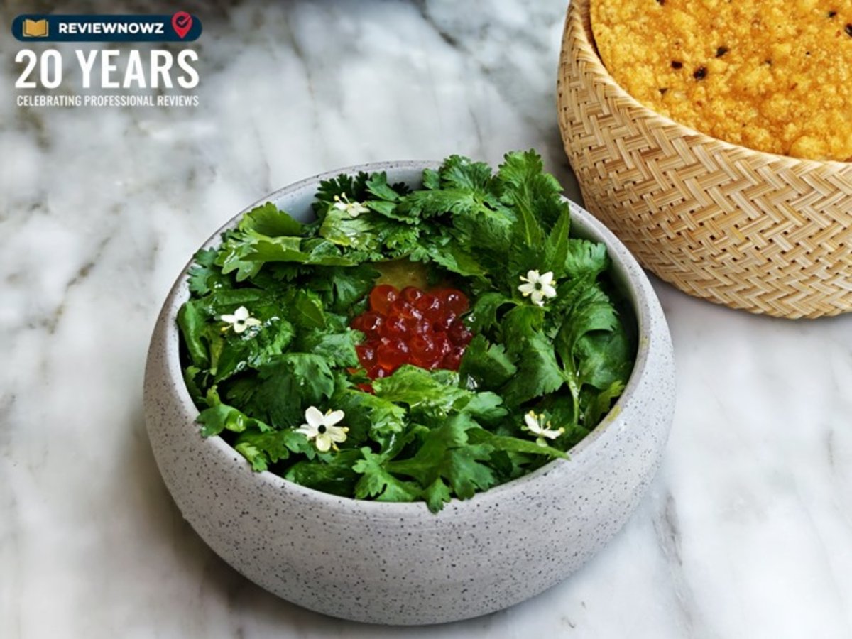 เมนู OJO Guacamole เสิร์ฟในชามหิน ตกแต่งด้วยผักชีสดสีเขียวขจีและท็อปด้วยไข่ปลาแซลมอนปริมาณมาก วางคู่กับตะกร้าใส่แผ่นตอร์ติญ่าทอดกรอบ ร้าน OJO Bangkok ชั้น 76 โรงแรม The Standard, Bangkok Mahanakhon ReviewNowz