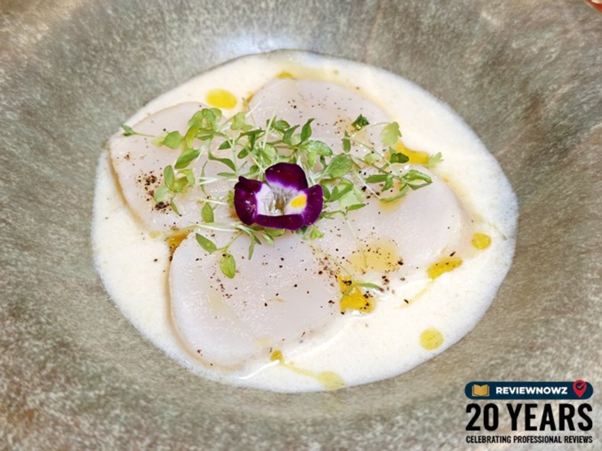 หอยเชลล์ฮอกไกโด, เมนู CRYSTAL SCALLOP, ห้องอาหาร Club Ruby โรงแรม AIDEN SURAWONG BANGKOK ภาพหอยเชลล์ Butter-confit ในซอส Champagne beurre blanc ตกแต่งด้วยไมโครเฮิร์บและดอกไม้กินได้ เสิร์ฟในจานลึก ReviewNowz
