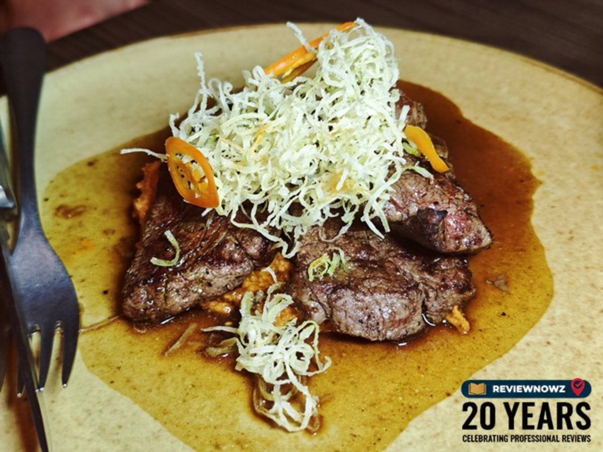 Angus Beef Tenderloin Burnt Ends สเต็กเนื้อสันในแองกัสราดซอส Romesco และ Jus ท็อปด้วย Shaved Almonds และ Crispy Leek ร้าน Madura Rooftop Bangkok ReviewNowz
