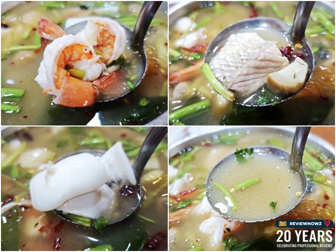 เครื่องต้มยำทะเลประกอบด้วยกุ้งสด เนื้อปลา และปลาหมึกชิ้นใหญ่ในกระบวยต้มยำน้ำใส ร้านครัวสุวรรณา วังหลัง ReviewNowz