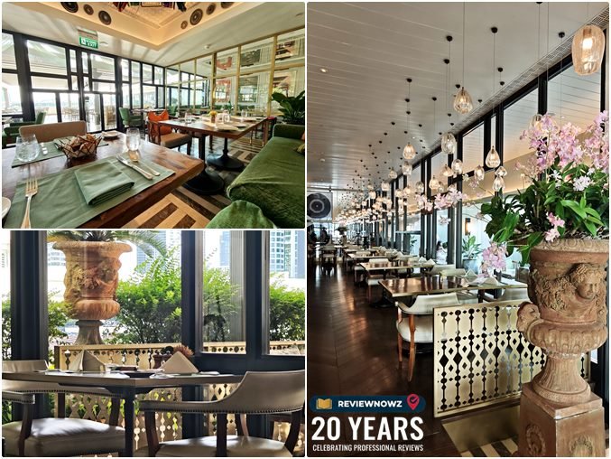 บรรยากาศภายในและโซนระเบียงริมน้ำของห้องอาหาร เดอะ เวอรันดา (The Verandah) โรงแรมแมนดาริน โอเรียนเต็ล กรุงเทพ ตกแต่งหรูหราสไตล์ร่วมสมัยด้วยโทนสีเบจ เฟอร์นิเจอร์ไม้ ประดับโคมไฟแก้วและแจกันดอกกล้วยไม้ พร้อมวิวโค้งแม่น้ำเจ้าพระยา ReviewNowz