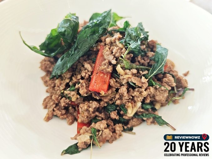 ผัดกะเพราเนื้อสับผัดแห้งเข้มข้น โรยใบกะเพราและพริกชี้ฟ้าแดง จัดวางในจานสีขาว ห้องอาหารเดอะ เวอรันดา โรงแรมแมนดาริน โอเรียนเต็ล กรุงเทพ ReviewNowz